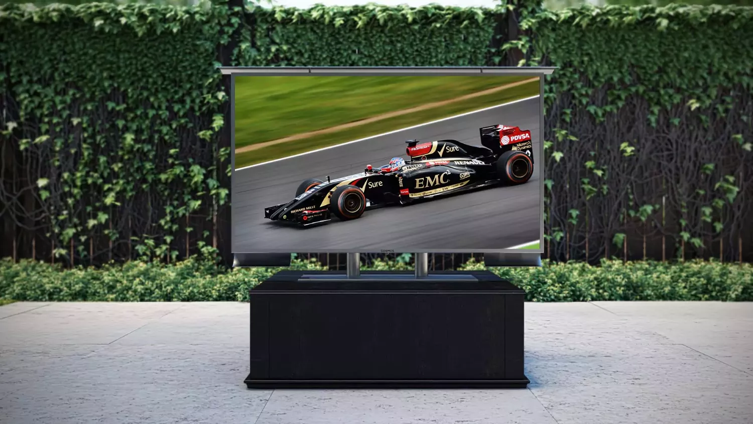 A table-mounted outdoor TV shows a racing car set in a backyard.