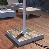 Stone base mount for outdoor TV with colored slate base and stainless steel pole in a patio.