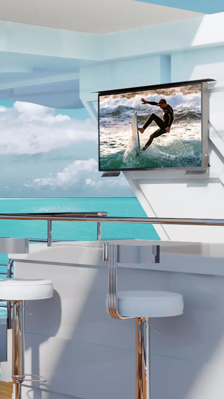 Elegant white sitting on a yacht with an outdoor TV shows a man surfing.