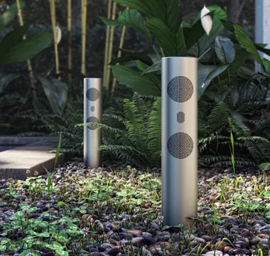 A soundwave cylinder speaker in a garden.