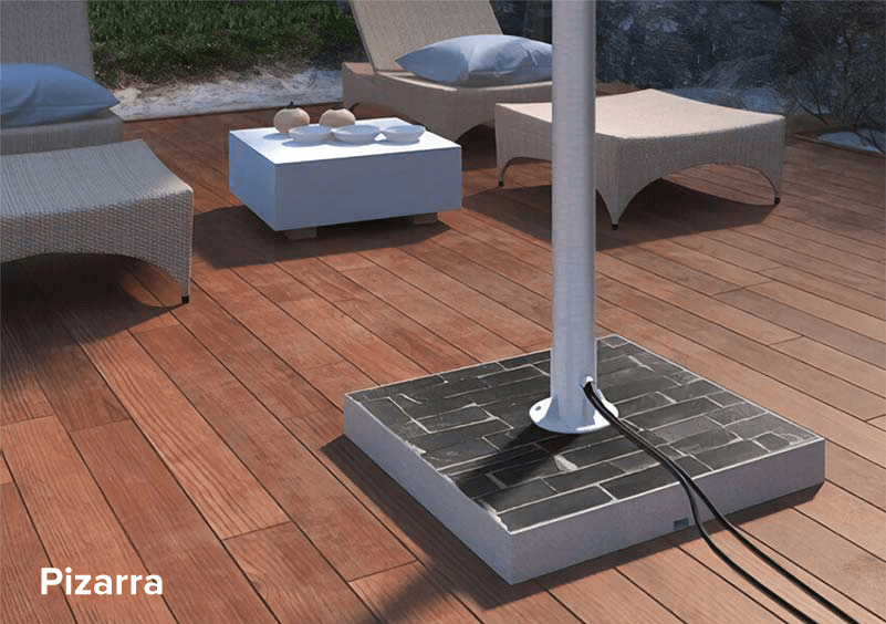 Black slate stand for an outdoor TV on a wooden deck board floor.