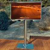 Self standing mount outdoor TV with cloudy orange sky on the screen in a wooden deck outside.