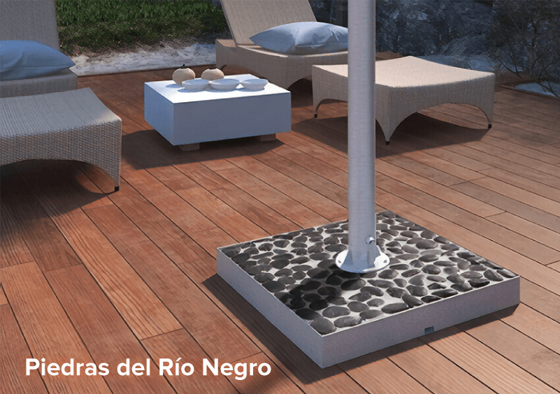 Black river stones stand for an outdoor TV on a wooden deck board floor.