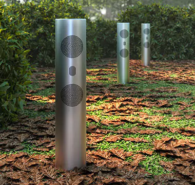 Three soundwave cylinders for high-quality audio in a garden.