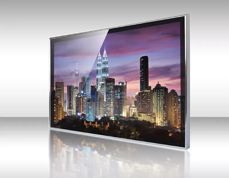 Televisor espejo enmarcado de aluminio plateado mostrando altos edificios en una ciudad.