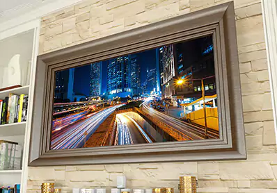 TV espejo clásico con marco de madera montado en una pared de ladrillo.