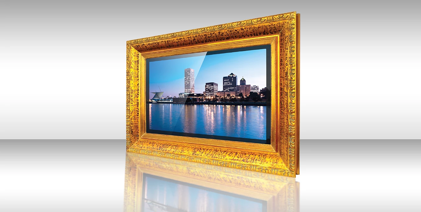 Un marco dorado ornamentado mostrando un horizonte urbano al atardecer en un TV espejo DecoVue Colon.