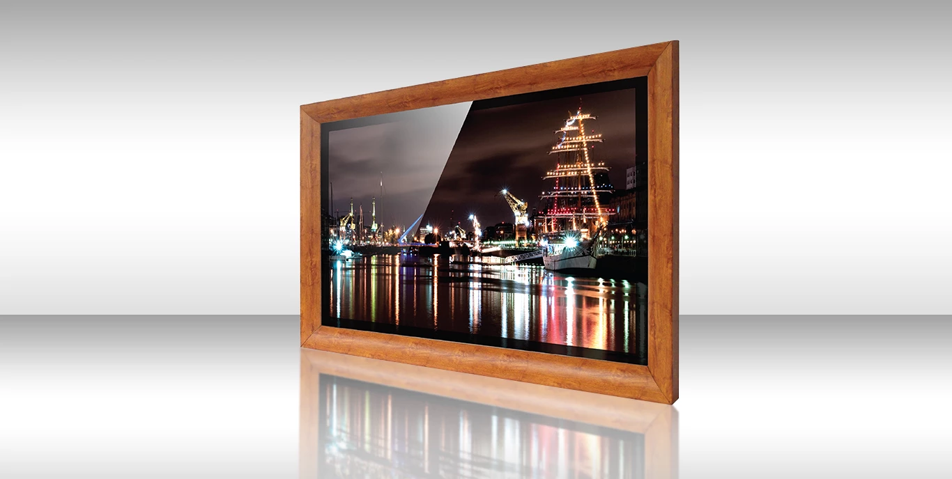 Un TV espejo con marco de madera en una habitación blanca muestra un hermoso paisaje.