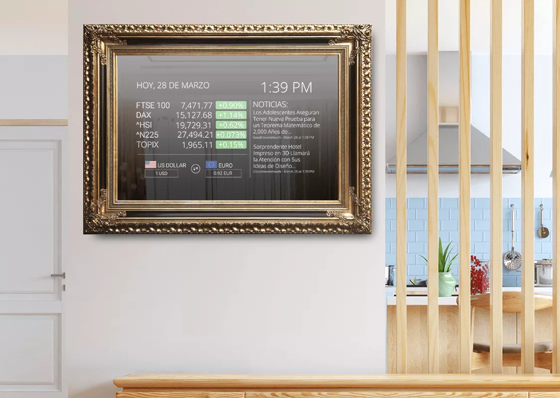 Un TV espejo inteligente con marco dorado instalado en una pared blanca en una cocina.