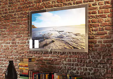 TV espejo con marco montado sobre una pared de ladrillo sobre una pila de libros y un jarrón de flores a la derecha.