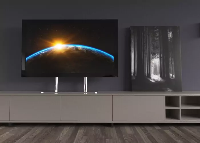 Sala de estar acogedora con un TV espejo sin marco montado sobre un escritorio sobre un mueble taupe con detalles en relieve.