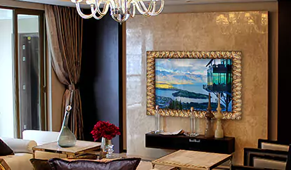 Un TV espejo con marco dorado montado en una pared cerámica en una sala de estar sofisticada.