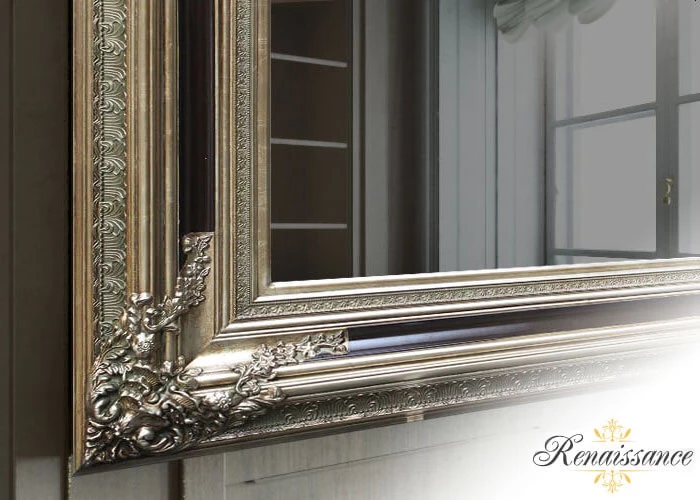 Marco renacentista dorado de un TV espejo sobre una pared de madera.