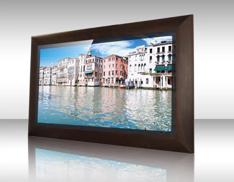 Vista de un canal con edificios coloridos y un cielo azul en el TV espejo con marco de madera Karis.