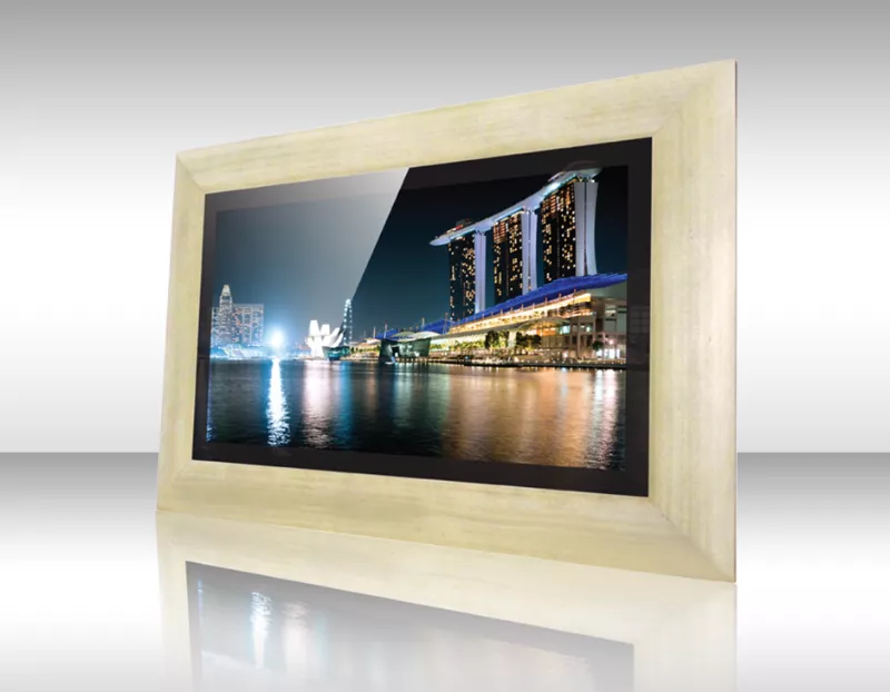 Vista previa de ciudad costera iluminada de noche mostrada en televisor espejo enmarcado.