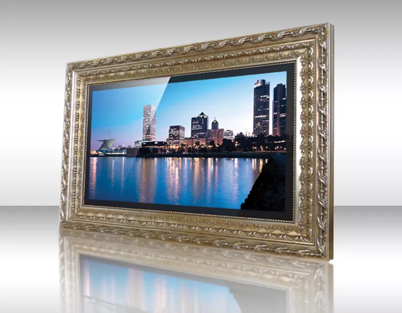Televisor espejo enmarcado presenta vista urbana costera con edificios iluminados.