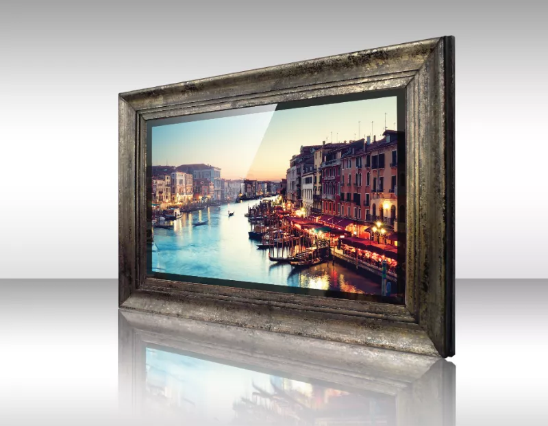 Televisor espejo enmarcado presenta vista de canal al anochecer con edificios iluminados.