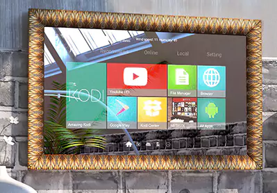 TV espejo con marco de madera dorada colocado sobre una pared de ladrillo negro.