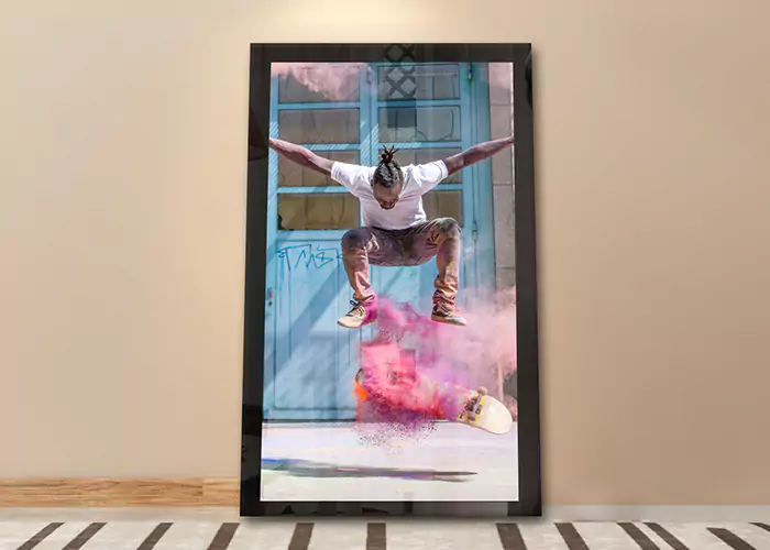 Un TV espejo recargado sobre la pared muestra a un hombre haciendo trucos con patineta con polvo azul y naranja.