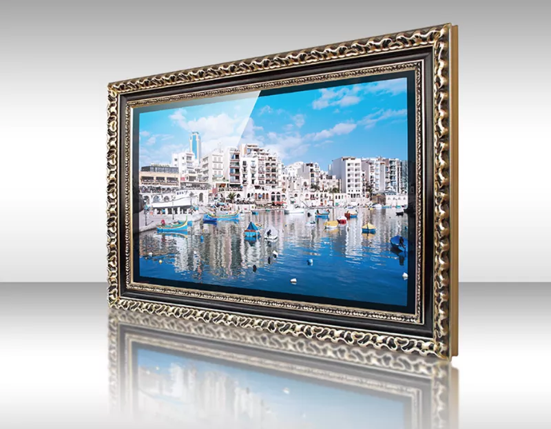 Televisor espejo con marco dorado Cayo mostrando paisaje urbano costero con barcos y edificios bajo cielo azul.