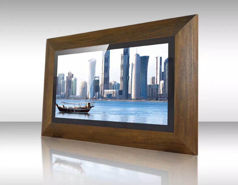 Televisor espejo enmarcado de madera maciza mostrando horizonte urbano moderno con bote en el agua.