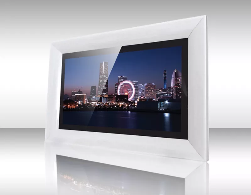 Televisor espejo enmarcado blanco mostrando horizonte urbano nocturno con edificios iluminados.