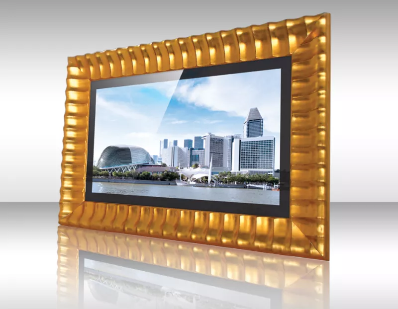 Televisor espejo enmarcado con marco dorado acanalado mostrando horizonte urbano con edificios modernos.