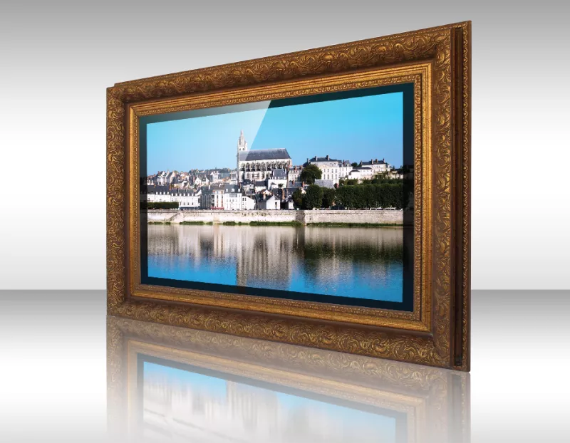 Televisor espejo con marco dorado ornamentado mostrando paisaje ribereño.
