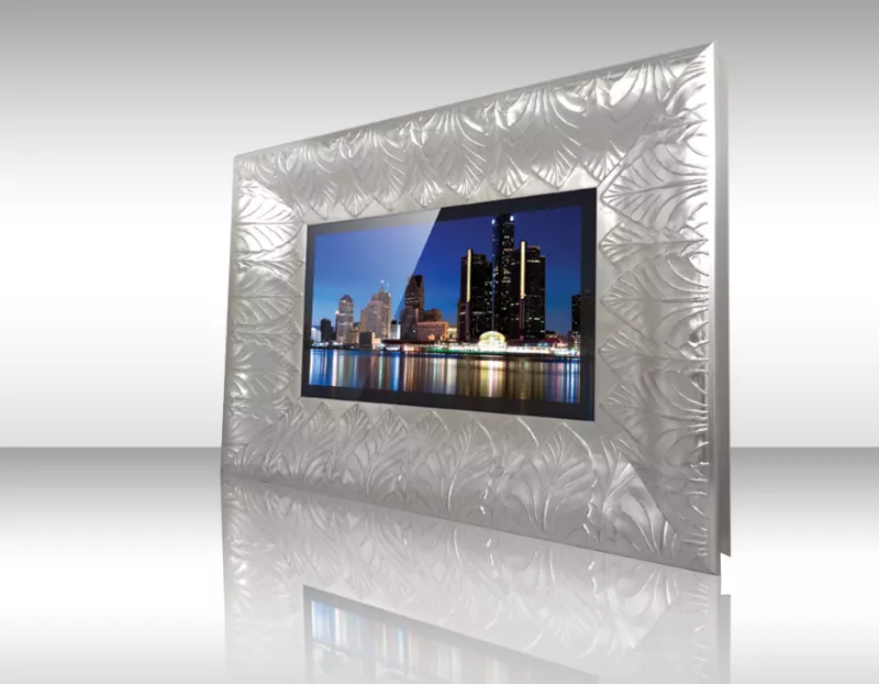 Televisor espejo con marco oscuro mostrando ciudad costera con edificios coloridos y cielo azul.