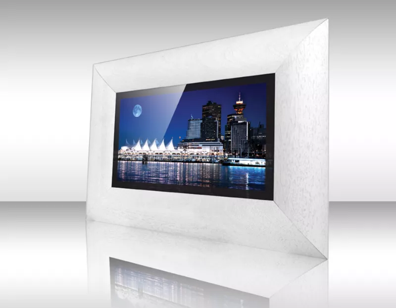 Televisor espejo con marco blanco Volos mostrando horizonte urbano con luna llena y edificios iluminados.