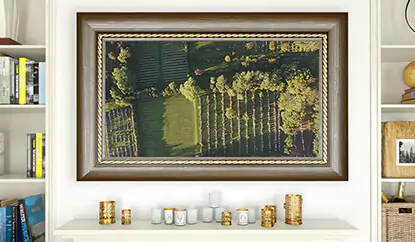 TV espejo con marco de madera sobre una pared blanca sobre un mostrador con velas y estantes a ambos lados.