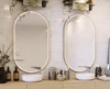 Thumbnail of two oval lighted mirrors mounted to a stylish wall and a dual sink vanity in Ajman.