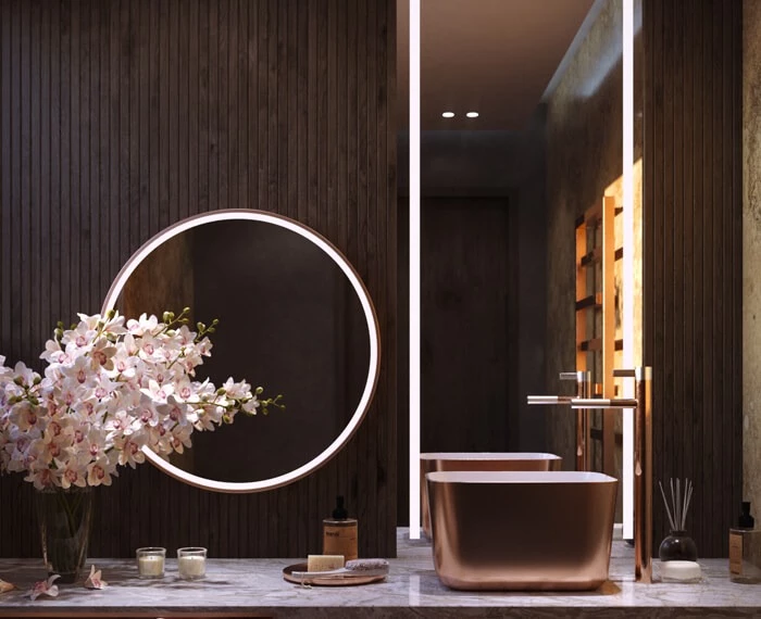 Dark wood panel wall with lit mirrors, a golden basin, and an orchid in a fancy bathroom in Bahrain.