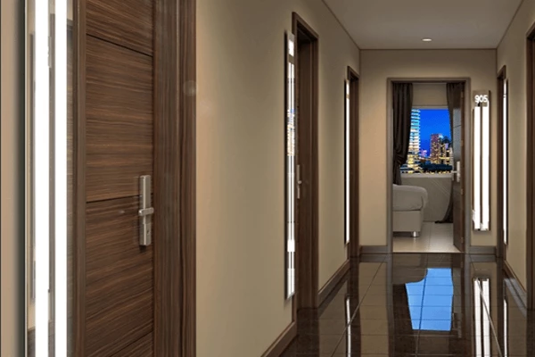 Lighted mirrors beside hotel rooms with a glossy brown tiled floor and a beige wall in Bahrain.
