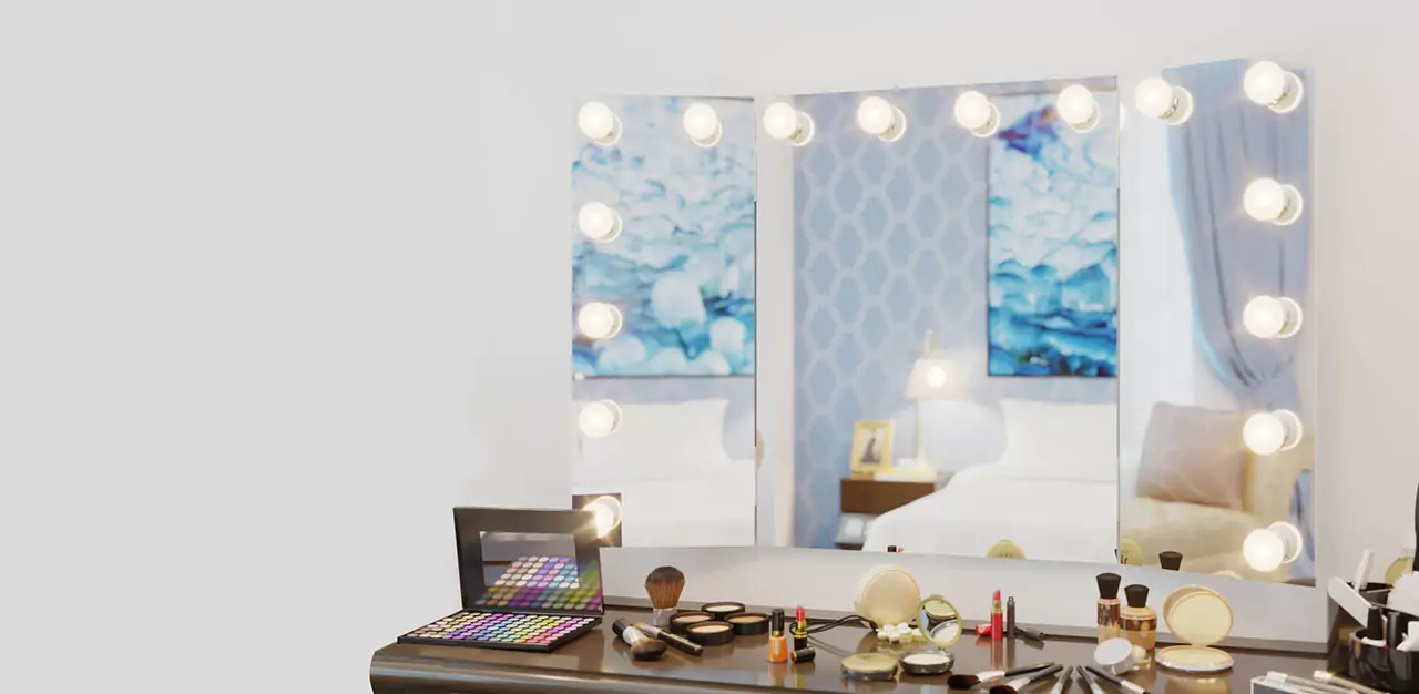 Above a makeup necessities table, there's a wall mounted trifold Hollywood mirror from Bahrain.