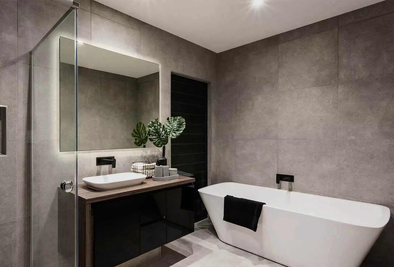 Wall mounted bespoke illuminated mirror in a minimalist bathroom that has plants from UAE.