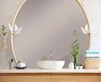 A tiny of circular lighted vanity mirror in a bathroom with a chic lamp provides light from Dubai.