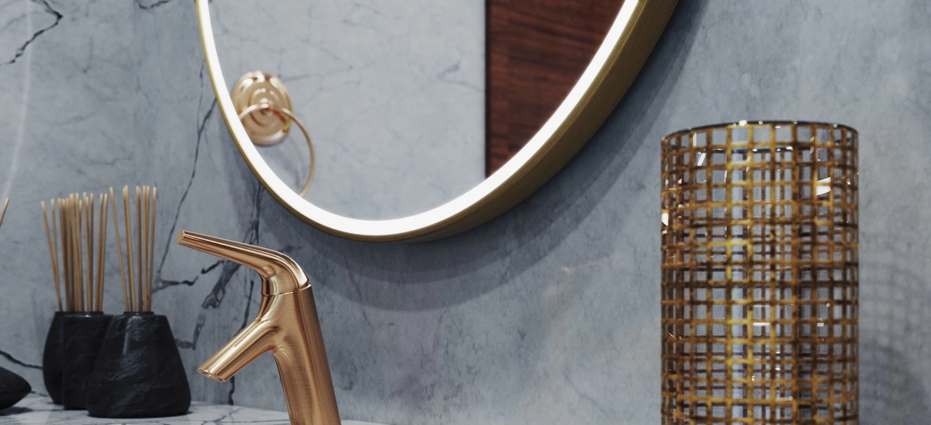 Bathroom vanity with a gold faucet, marble wall, and a round gold framed lighted mirror in Sharjah.