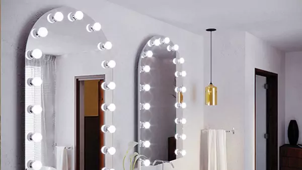Tiny of a Hollywood mirror with two sinks arranged in an arch on a white wall from Dubai.