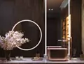 Compact of custom lighted mirrors, above an orchid, two scented candles, and a soap in Dubai.