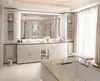 Compact of a bathroom with a hotel bathroom mirror lighting, two cabinets, and a bathtub in Ajman.