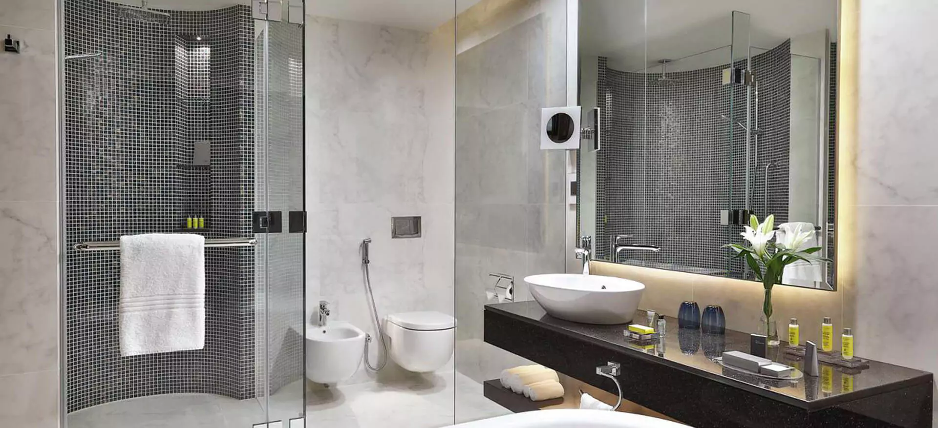 A beautiful backlit wall mounted mirror in an elegant bathroom that is from Dubai.