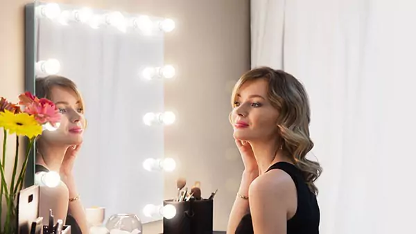 Thumbnail of a happy woman looks in a Hollywood mirror at herself from Saudi Arabia.