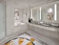 Thumbnail of bathroom with a marble wall in a grid pattern mounted with a vanity mirror in Kuwait.