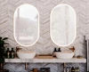 Preview of two oval lighted mirrors, a dual sink vanity, and bathroom essentials in Kuwait.