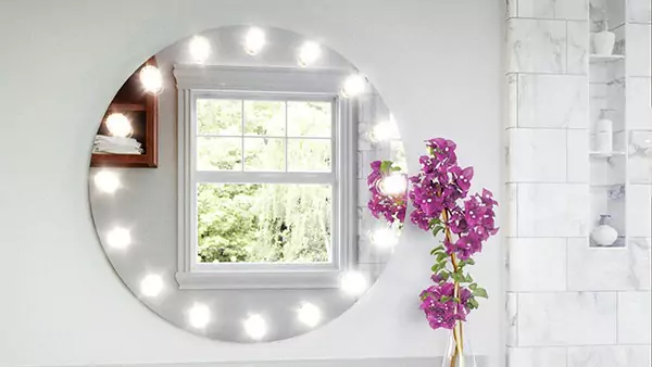 Icon of an ideal Bougainvillea flower, a circular Hollywood mirror is placed on a white wall in UAE.