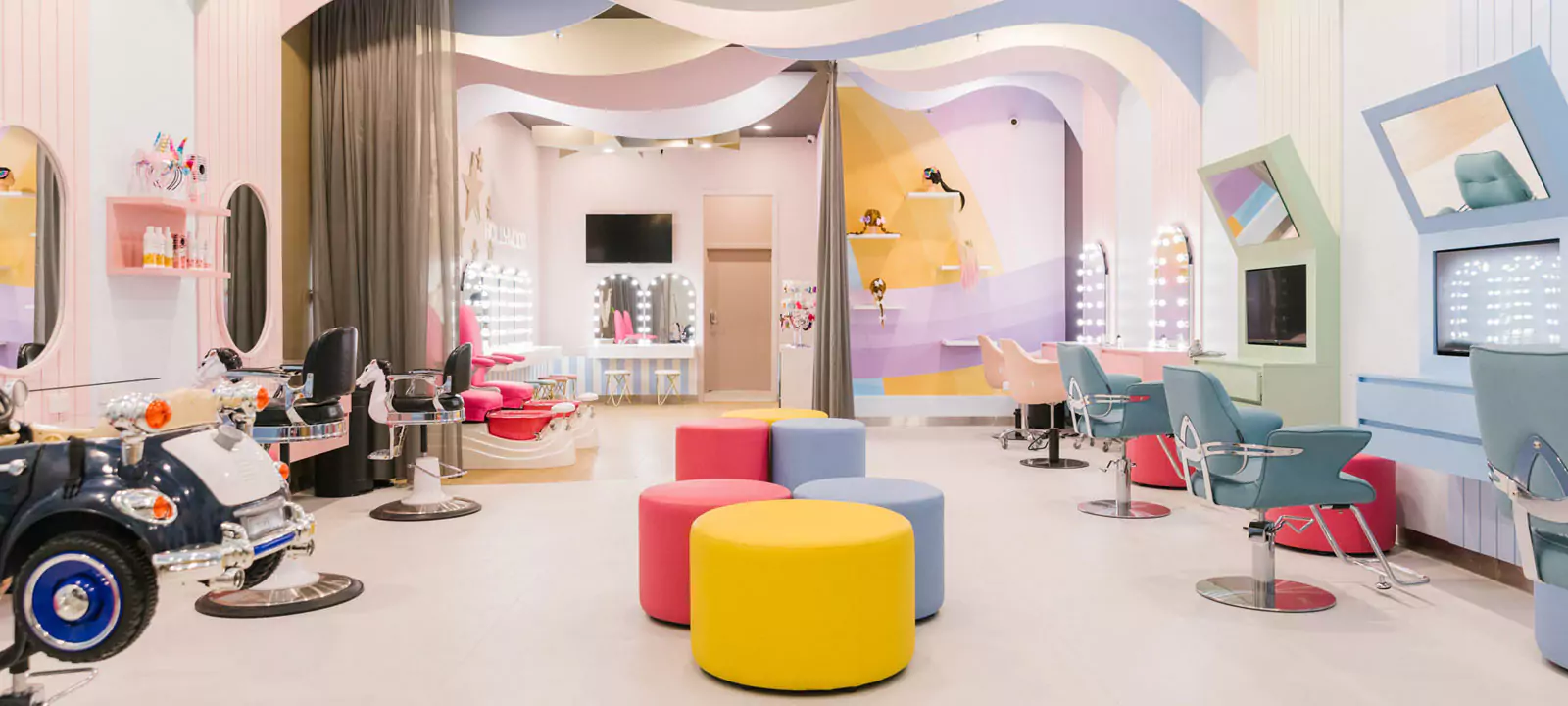 Oman Hollywood mirrors in the shape of arches and colorful chairs adorn this modern, bright salon.