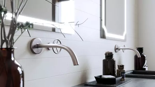 Lighted mirrors in Oman on a white concrete wall above the two sinks on a soapstone countertop.