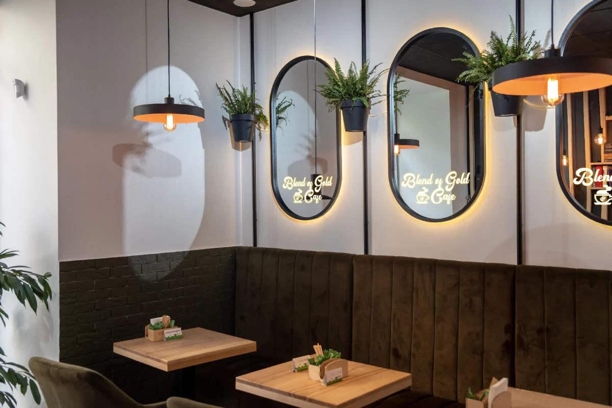 An oval shaped make up mirror reflects three people having a talk while seated at a bar in Qatar.