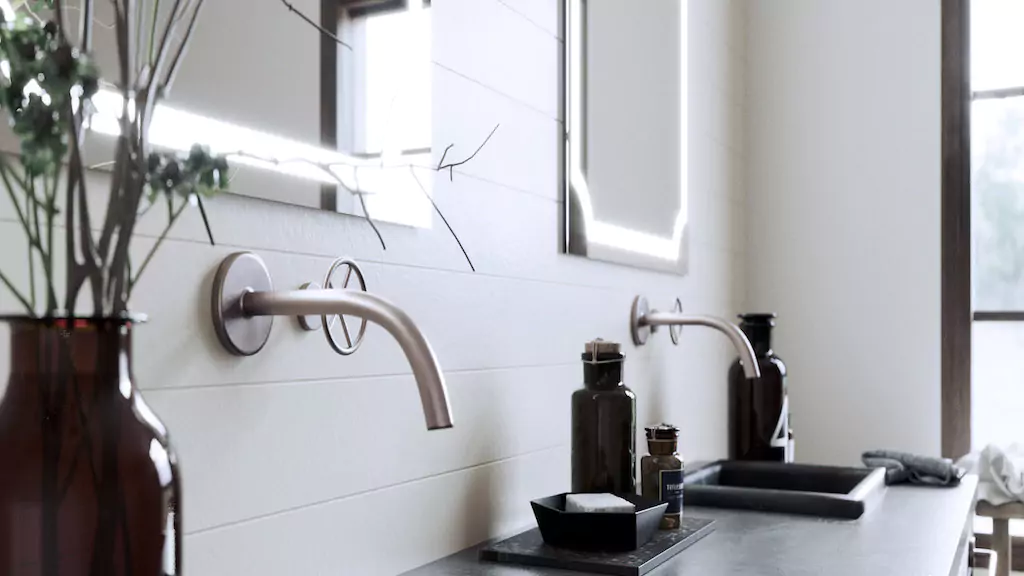 Vanity mirrors in Oman mounted on a white concrete wall with two stainless steel faucets with sinks.